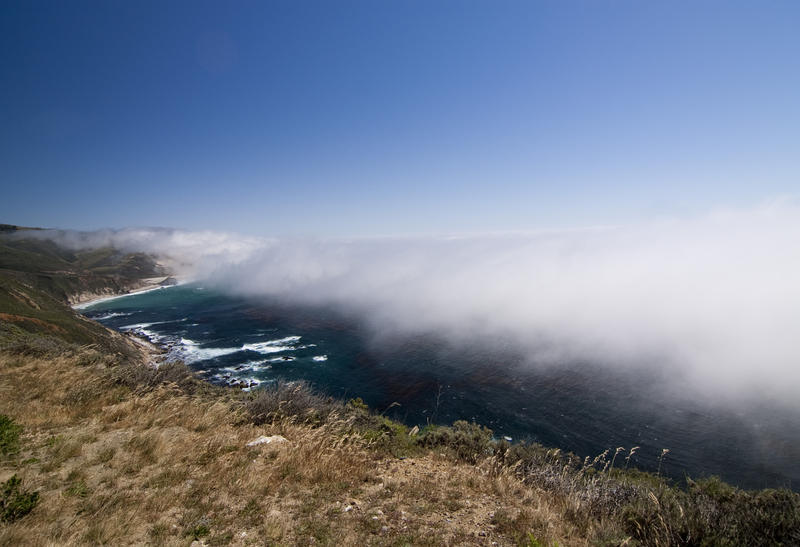 a layer of sea fog rolling over over the big sur coast line