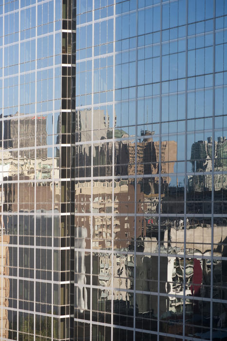 Urban reflections of skyscrapers in office windows of a modern corporate building on a sunny day