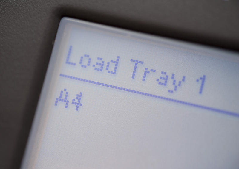 Load Tray message and digital display on an office printer or copier indicating that the paper has run out