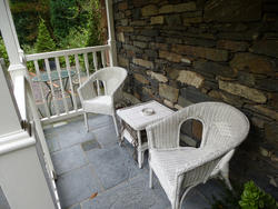 9850   Outdoors furniture on the porch of a stony house