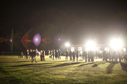 8894   People on a sports field lit by bright spotlights