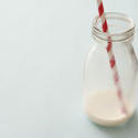 12999   Lone glass bottle nearly emptied of white milk