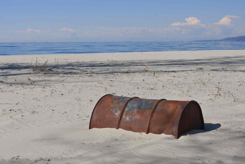 Old Rusty Oil Barrel Buried in Sand, End of Oil Age